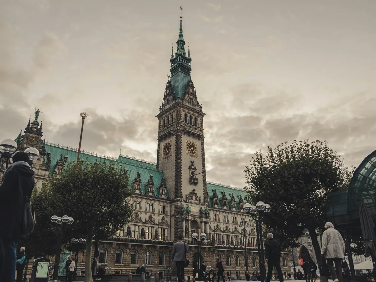 Hamburger Rathaus mit Turm und Menschen auf dem Rathausmarkt