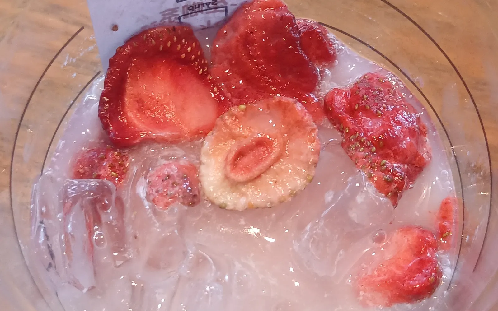 Starbucks Pink Drink mit Erdbeerstücken und Eis im Becher, von oben fotografiert