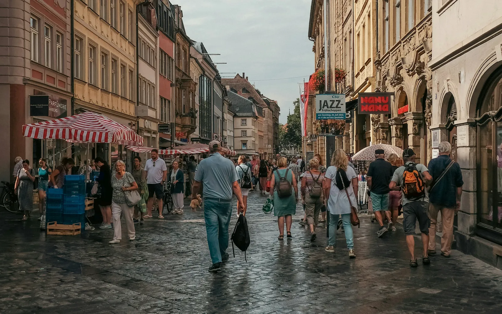 Belebte Fußgängerzone in einer deutschen Innenstadt mit Altbauten und Marktständen
