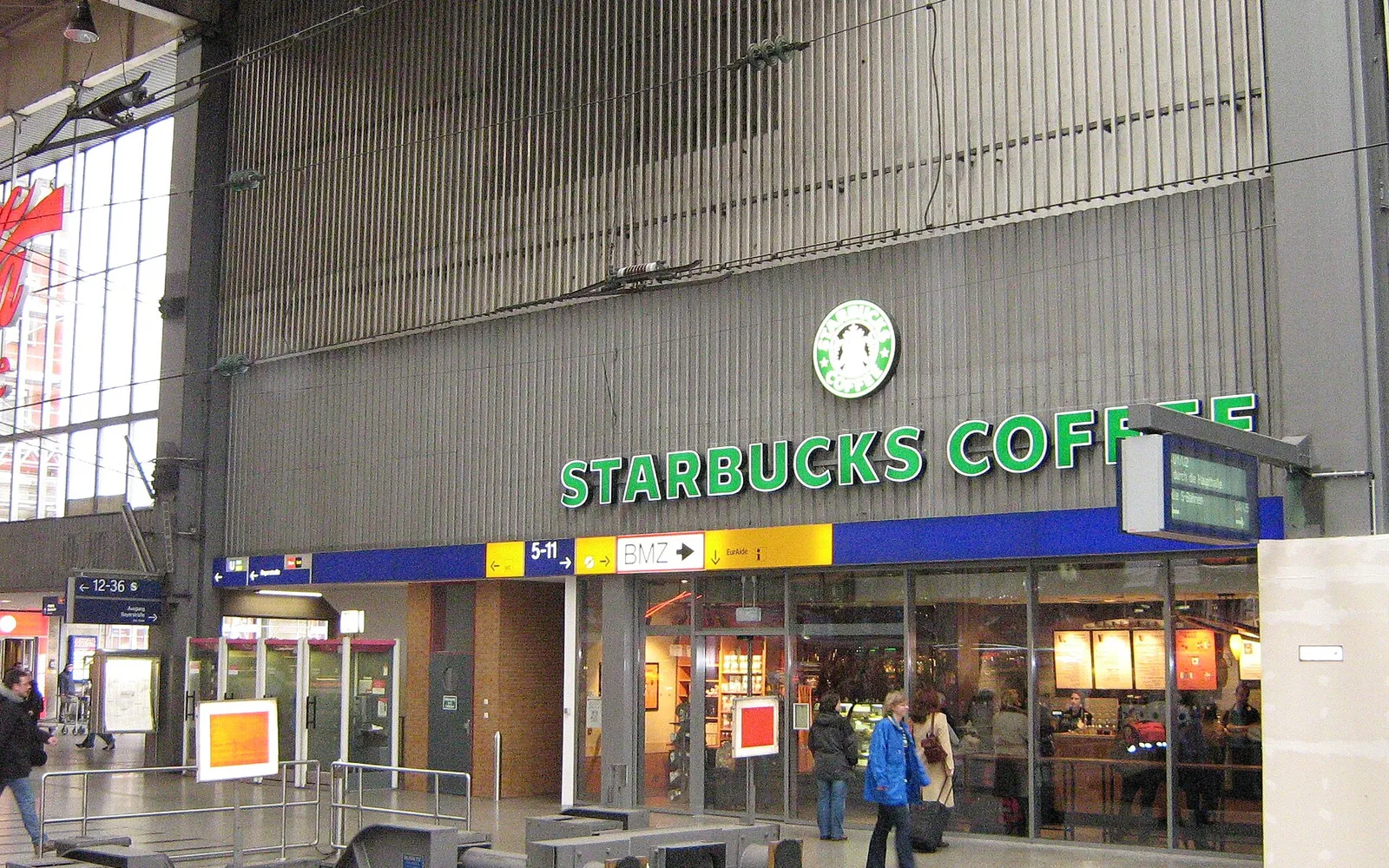 Starbucks Coffee House in der Halle des Münchner Hauptbahnhofs mit grünem Schriftzug über dem Eingang